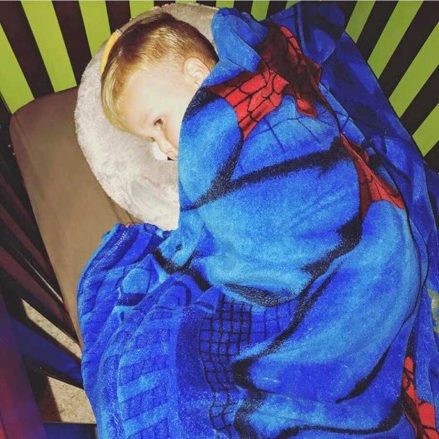 Mom takes a photo of her son sleeping in his bed with a Spiderman blanket after she forgot to take him to school