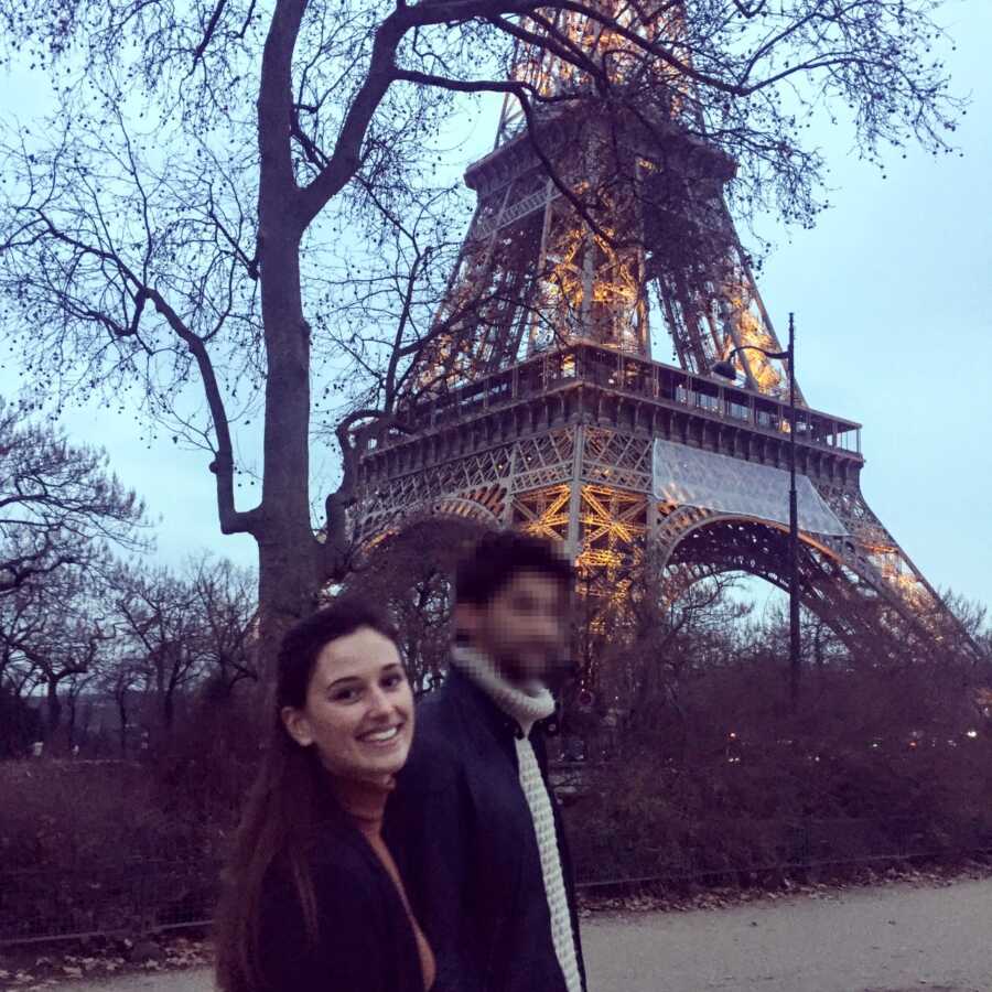 Young couple in love pose for a photo in front of the Eiffel Tower in France