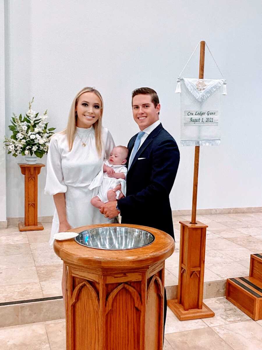 First time parents take a photo with their newborn son at his Christening
