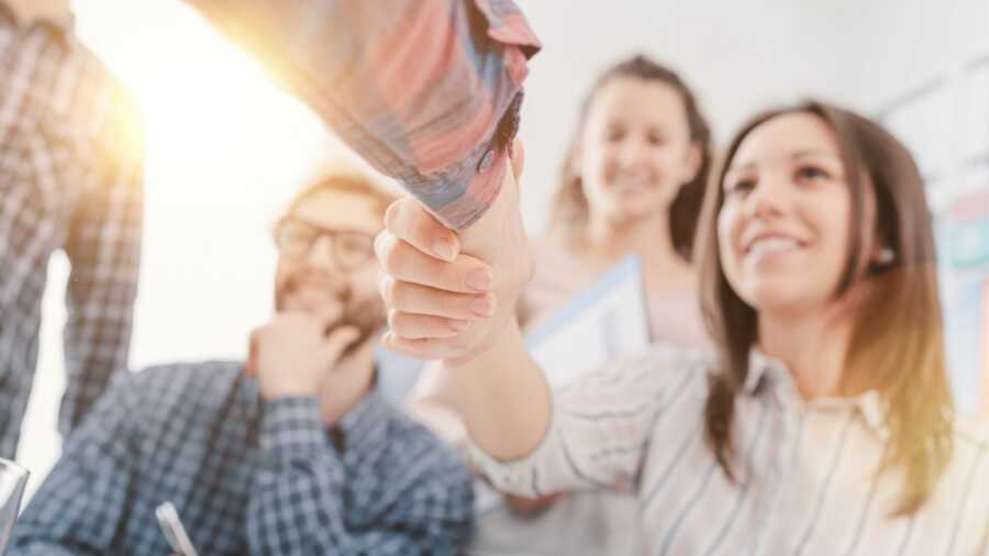 Two people shake hands, forming a mutually beneficial partnership. 