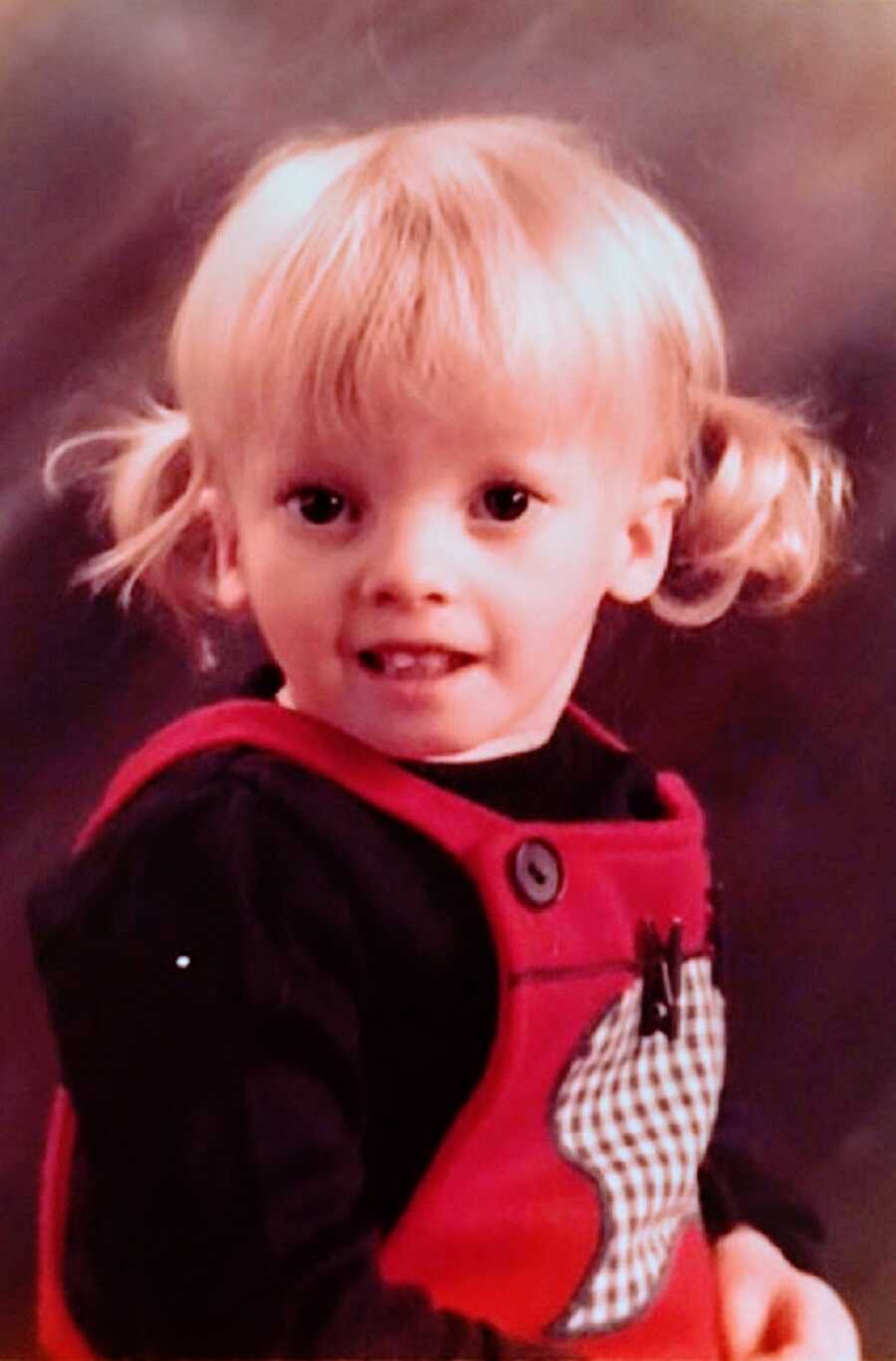 A girl with Russell-Silver Syndrome wearing overalls