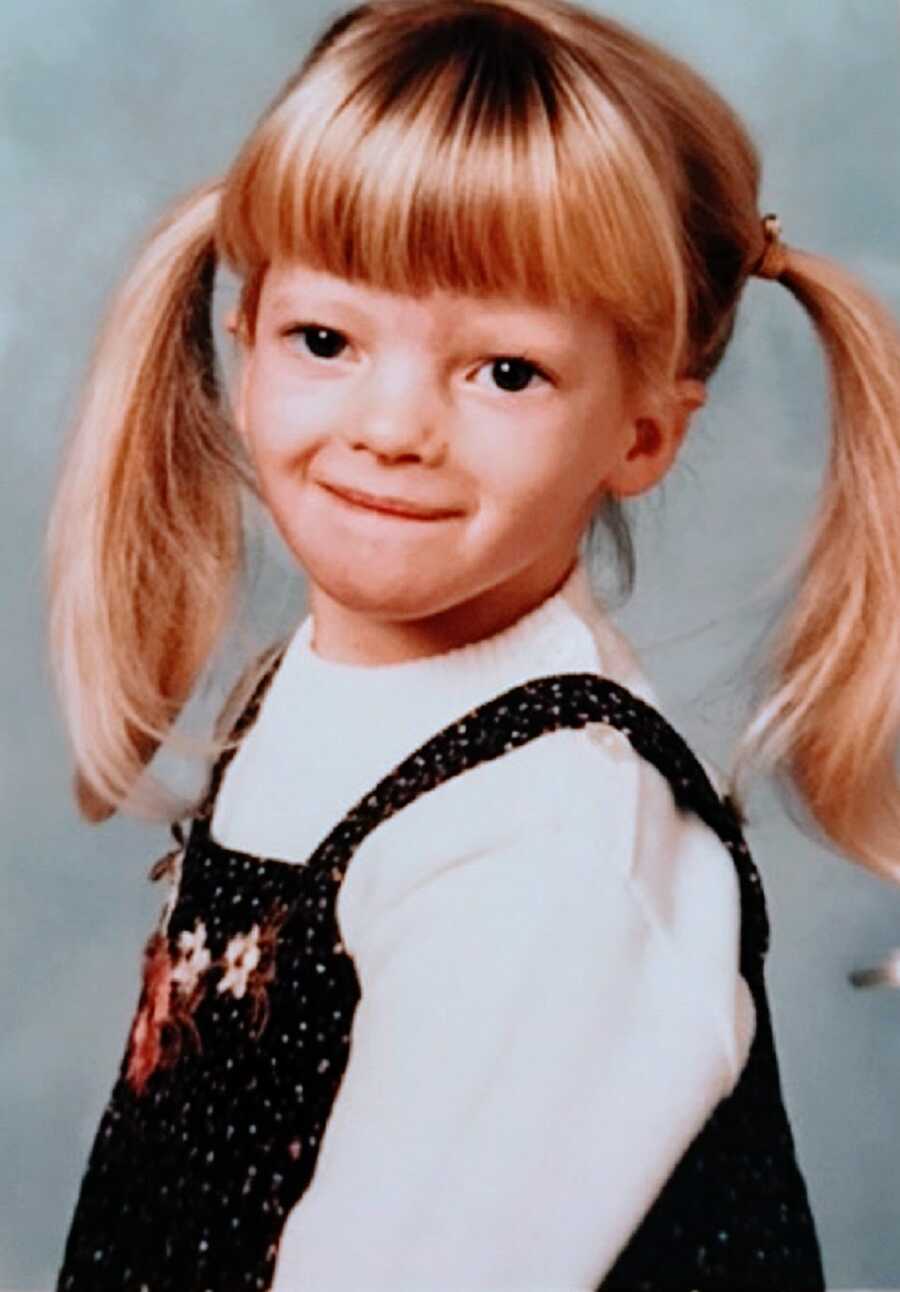 A girl with RSS wearing pigtails and overalls