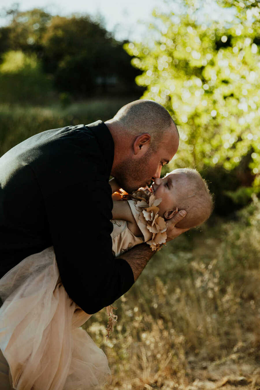 Dad embracing daughter with leukemia