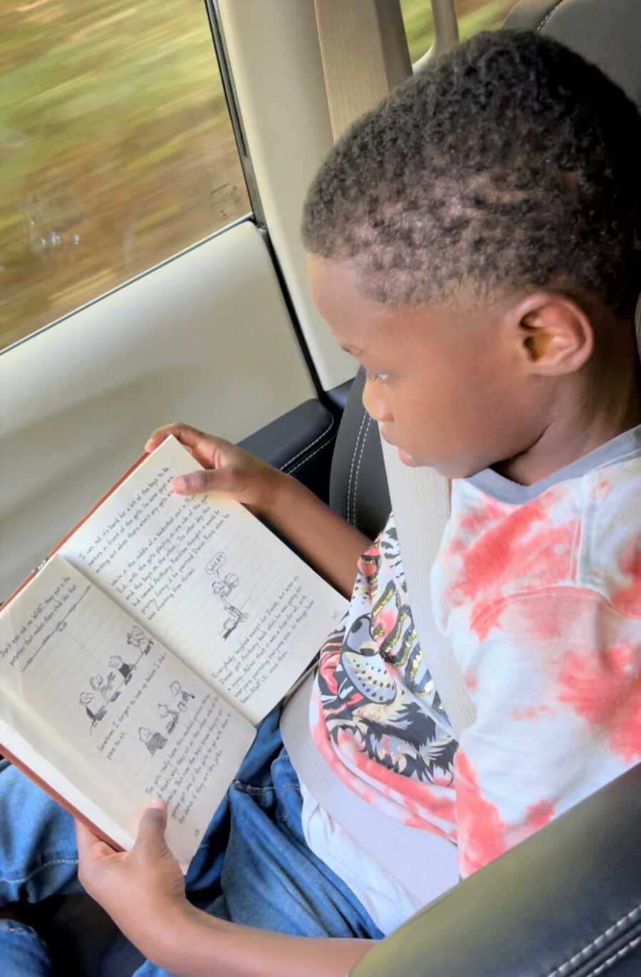 Dwayne, an avid reader, is buried in a book. 