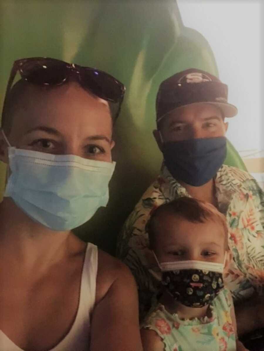 Parents and daughter wearing masks at Disneyland