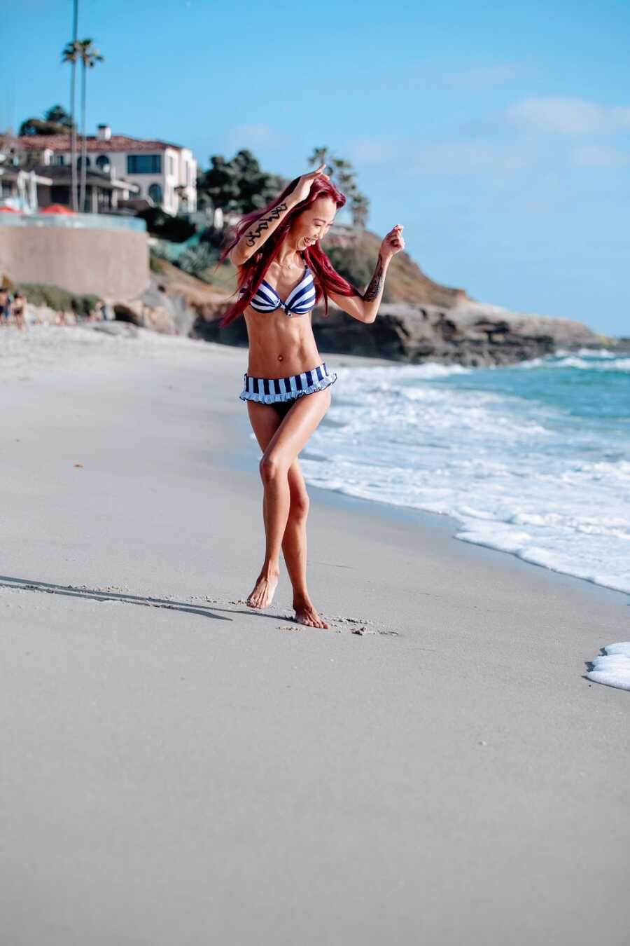 Woman with cerebral palsy wearing bathing suit on beach