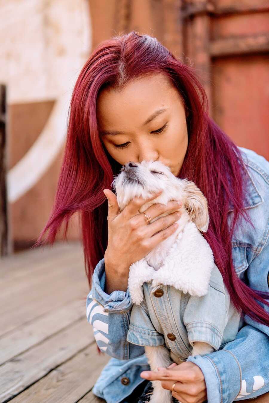 Woman with cerebral palsy kisses a small dog