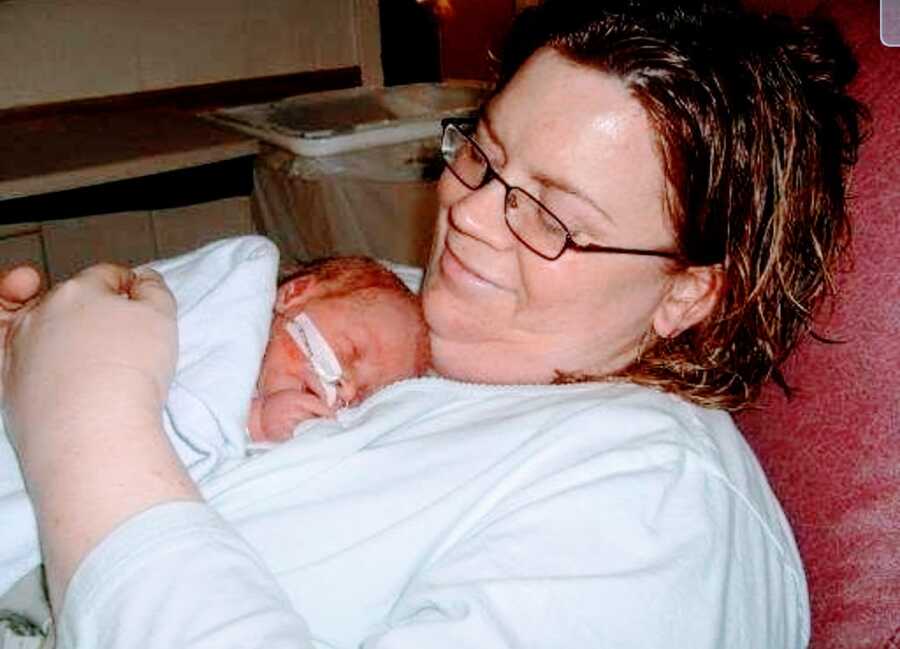 mother holds newborn twinless twin