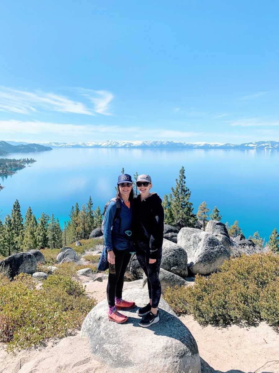 Recovering addict and another woman stand on a rock