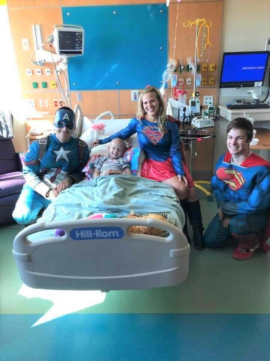 Firefighters pose for a picture with a young patient in the hospital.