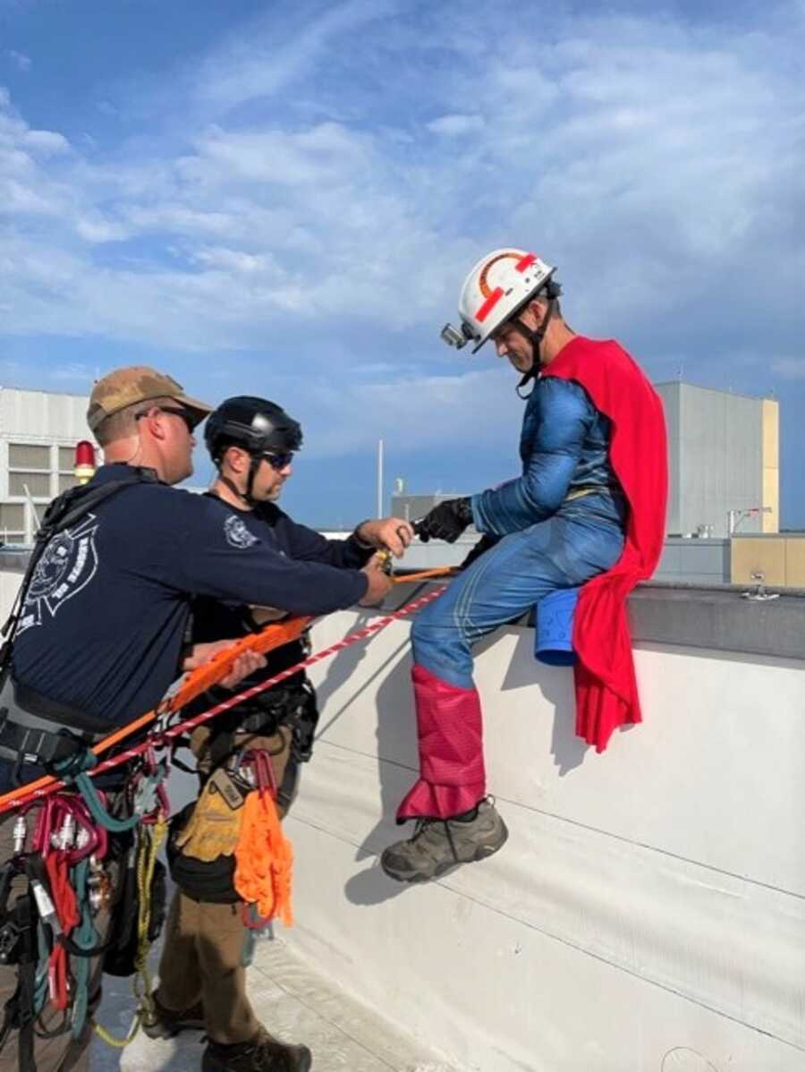Firefighter gets ready to repel down the side of the children's hospital.