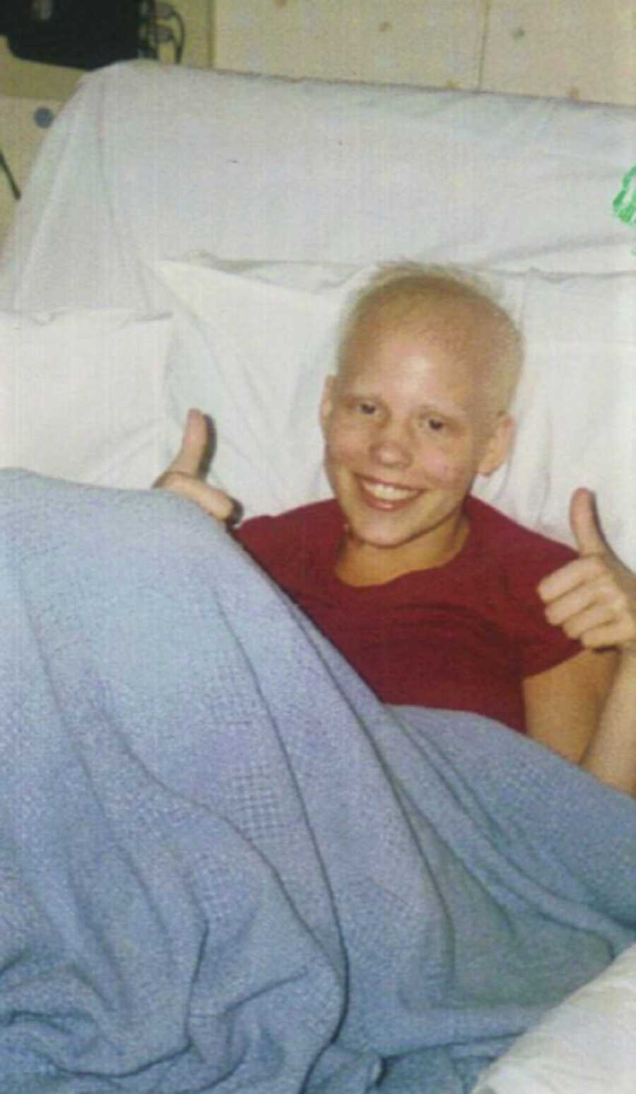 洛伦微笑着竖起两个大拇指，尽管她正在与儿童癌症作斗争。