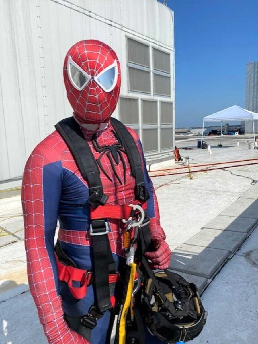 Firefighter wears Spiderman costume and repelling equipment. 