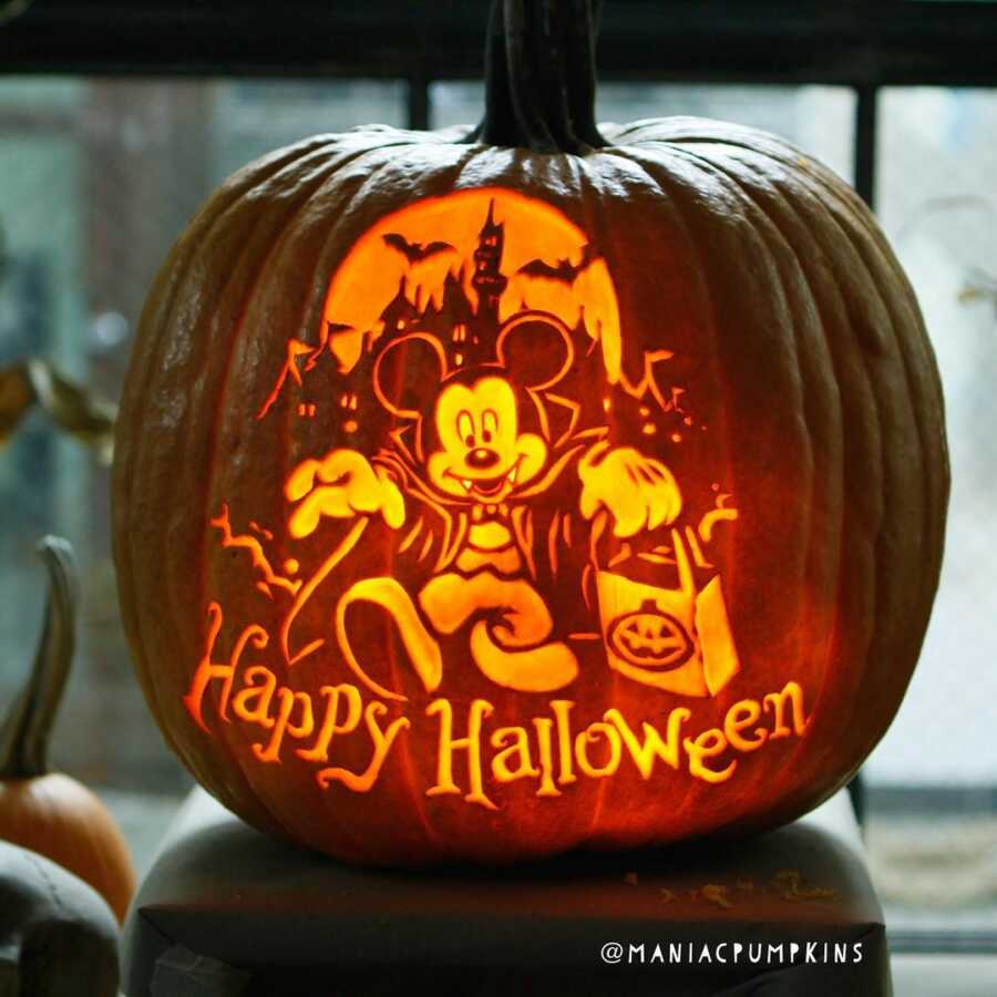 Pumpkin carving of vampire Mickey Mouse and haunted castle, created by Maniac Pumpkin Carvers. 