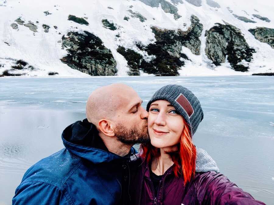 A man kisses his partner on the cheek