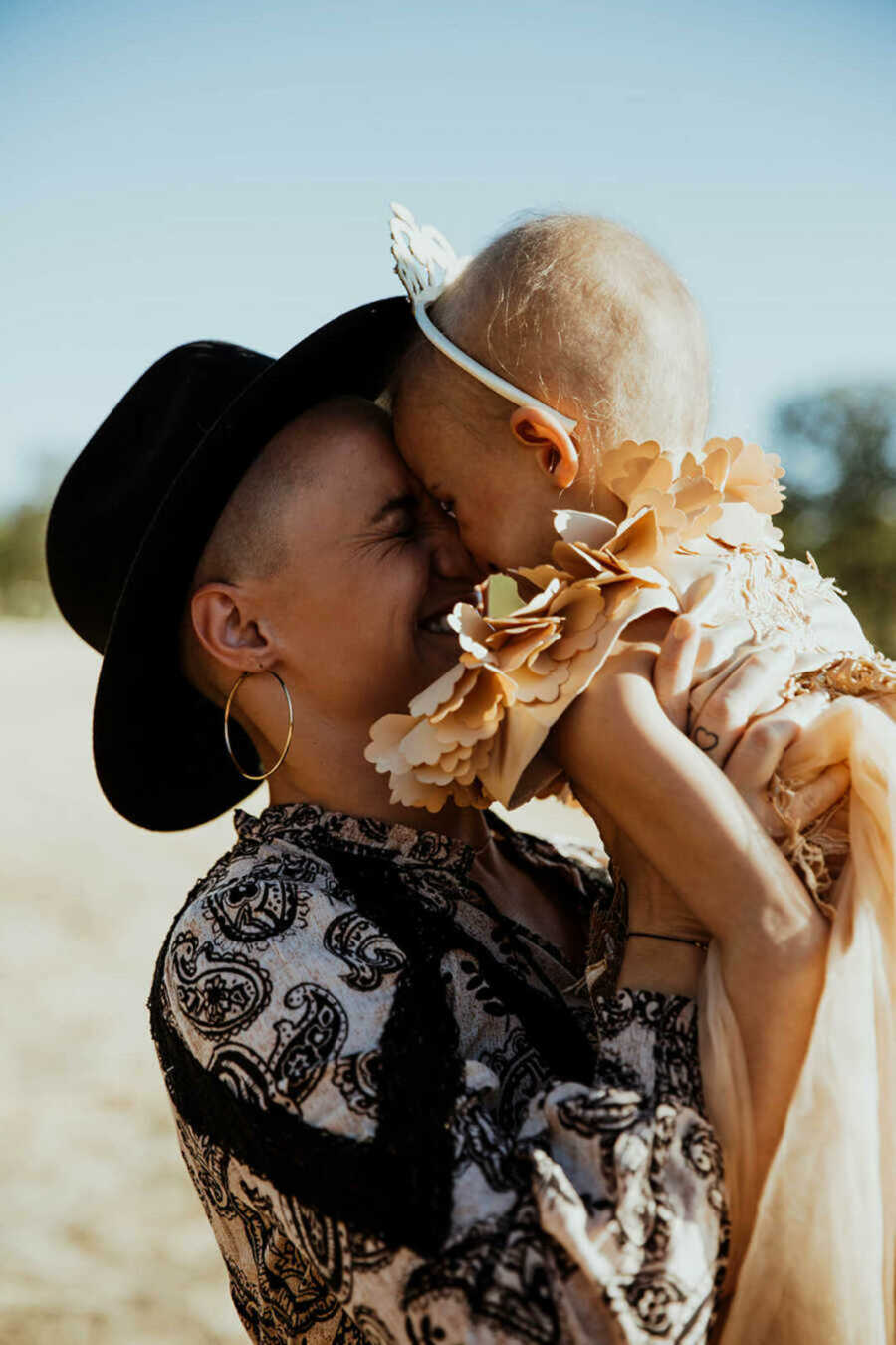 Mom snuggling daughter with leukemia