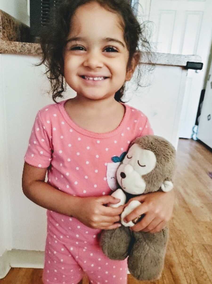 moms' daughter holding a toy she is about to give