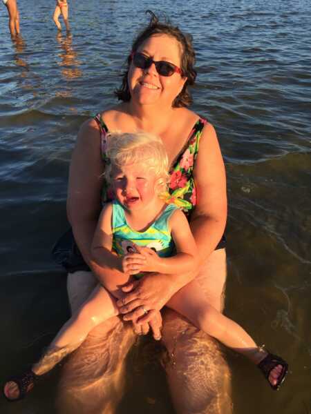 Toddler throwing a tantrum because she wanted to play in the water but not get wet.