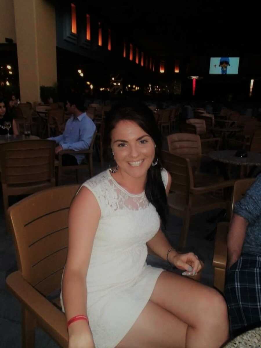 woman out to dinner taking a picture in a white dress at a resturant