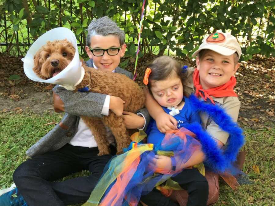brothers and sister dressed up for halloween with their dog