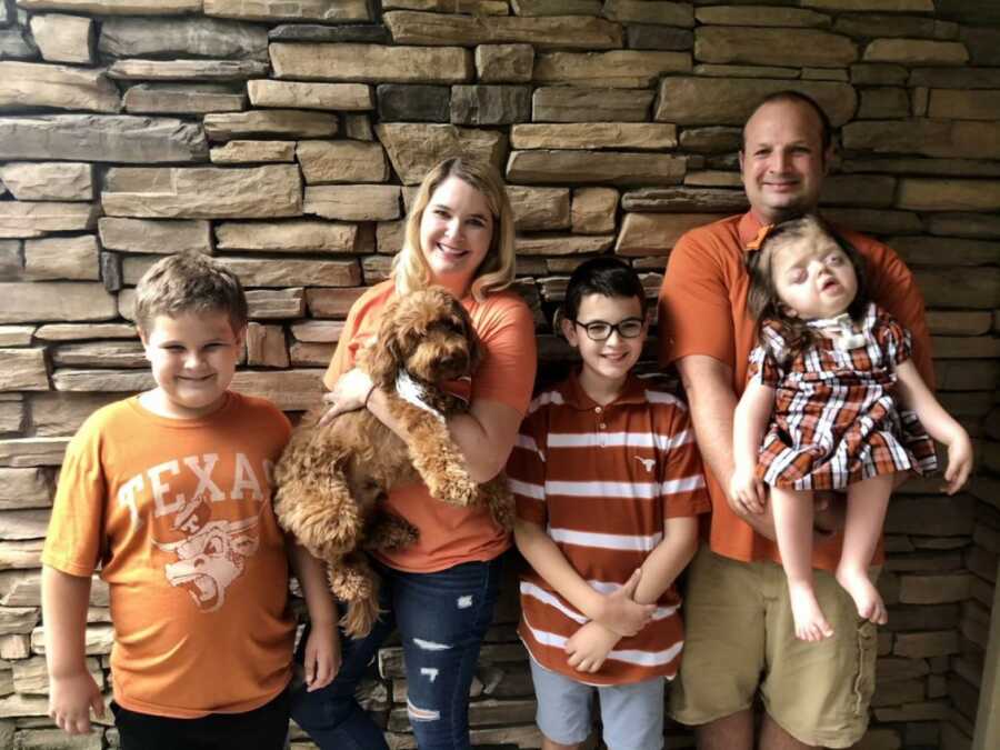 family photo with pops of orange and red with the family dog