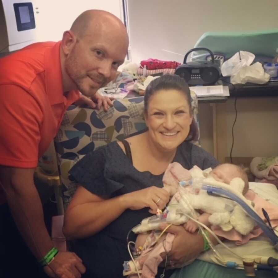 mom and dad holding their baby girl for the first time since she was born