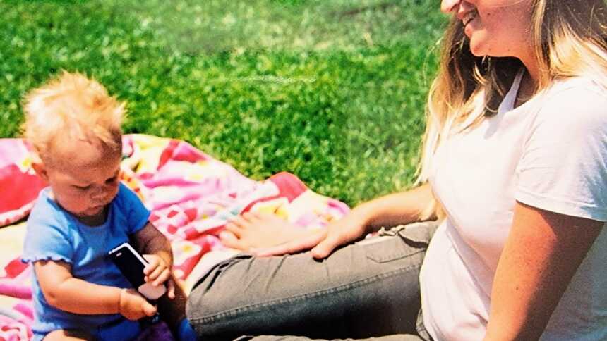 Mom sitting on the grass with her son 