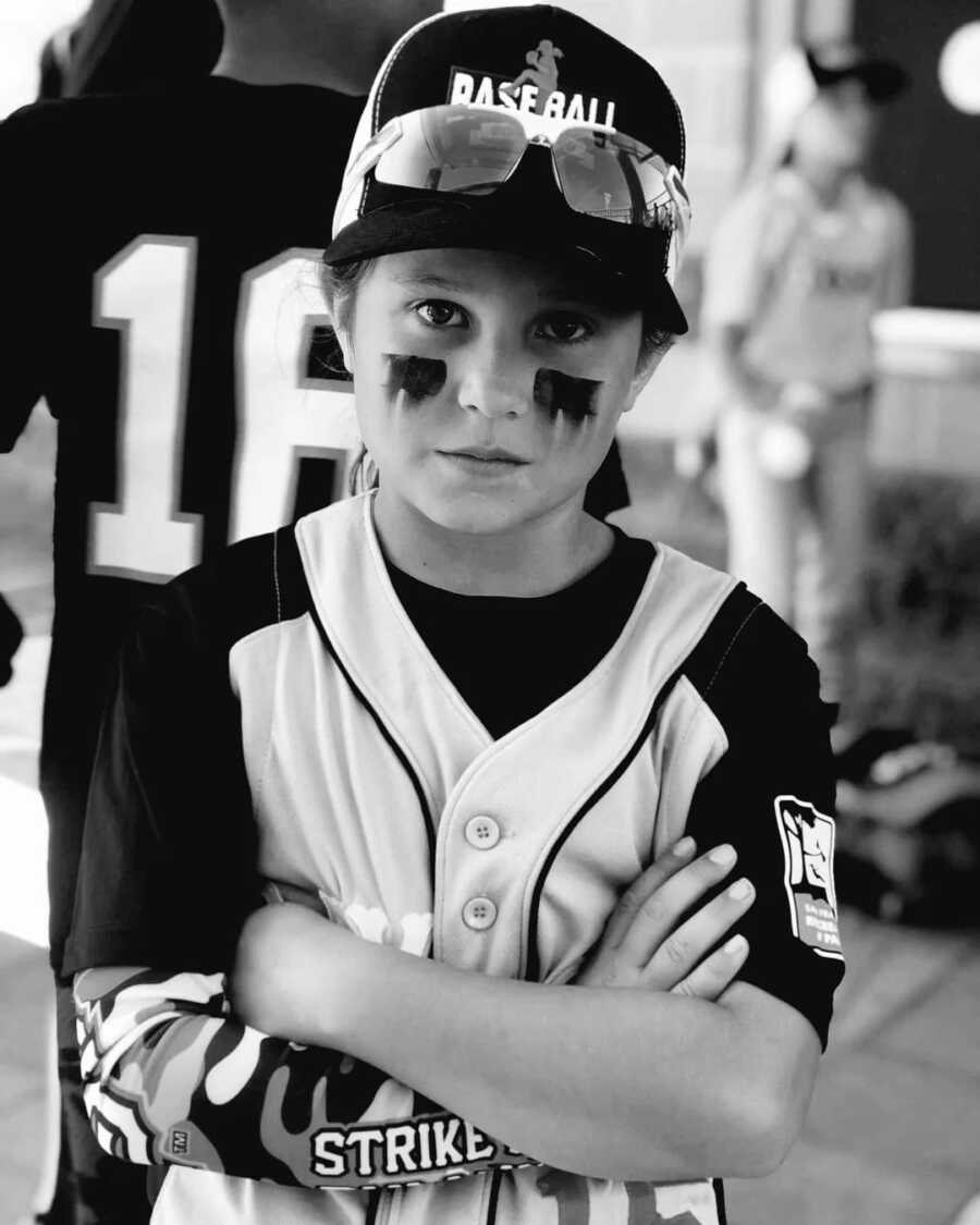 girl with her arms folded in her baseball jersey