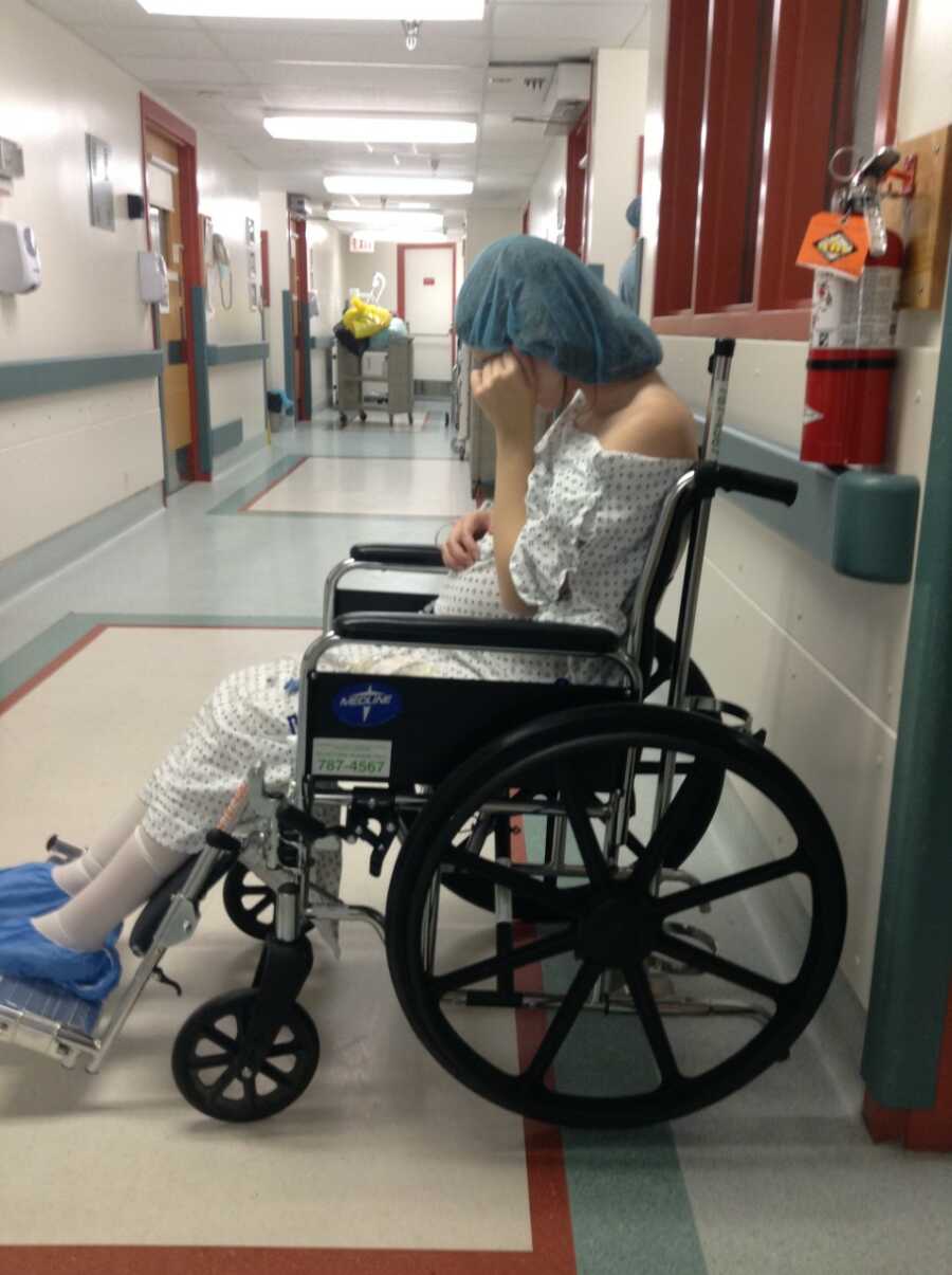 Teen mom sits in a wheelchair and cries after her C-section birth