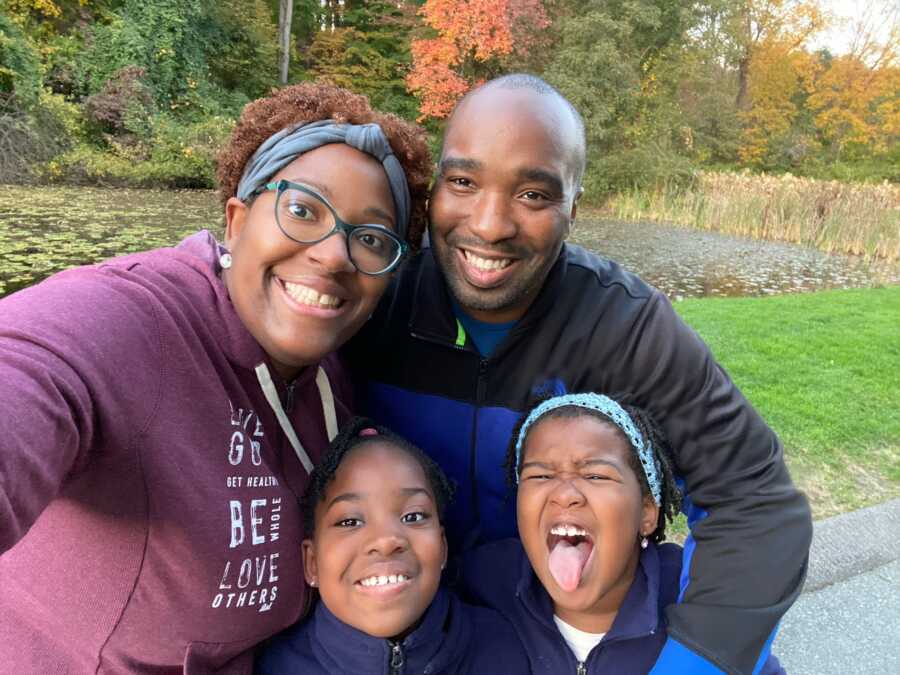 Family of four take a selfie together while on a walk, all wearing jackets