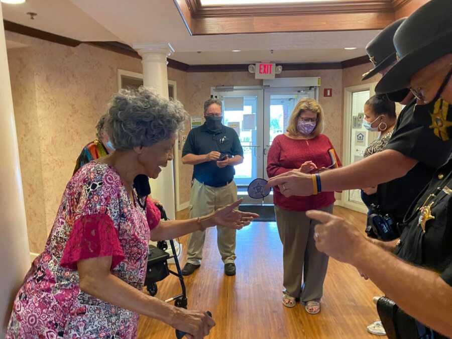 lady receiving a momento from the officer who helped her