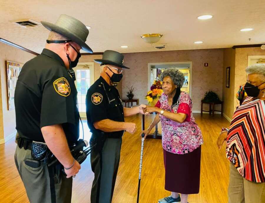 officers visiting the lady who complimented the officer for helping her fix her car