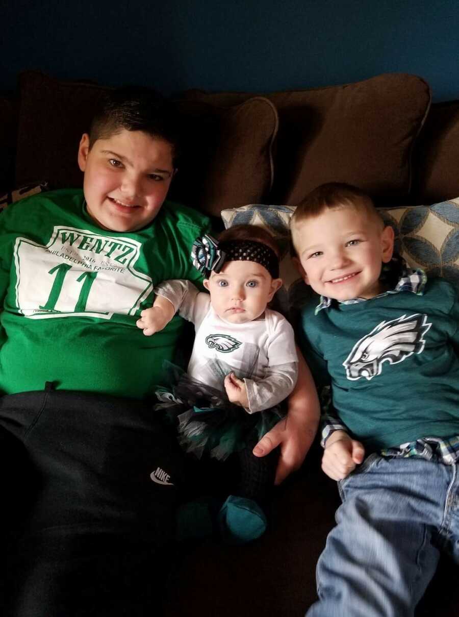 all three siblings smiling and in sports gear for a picture