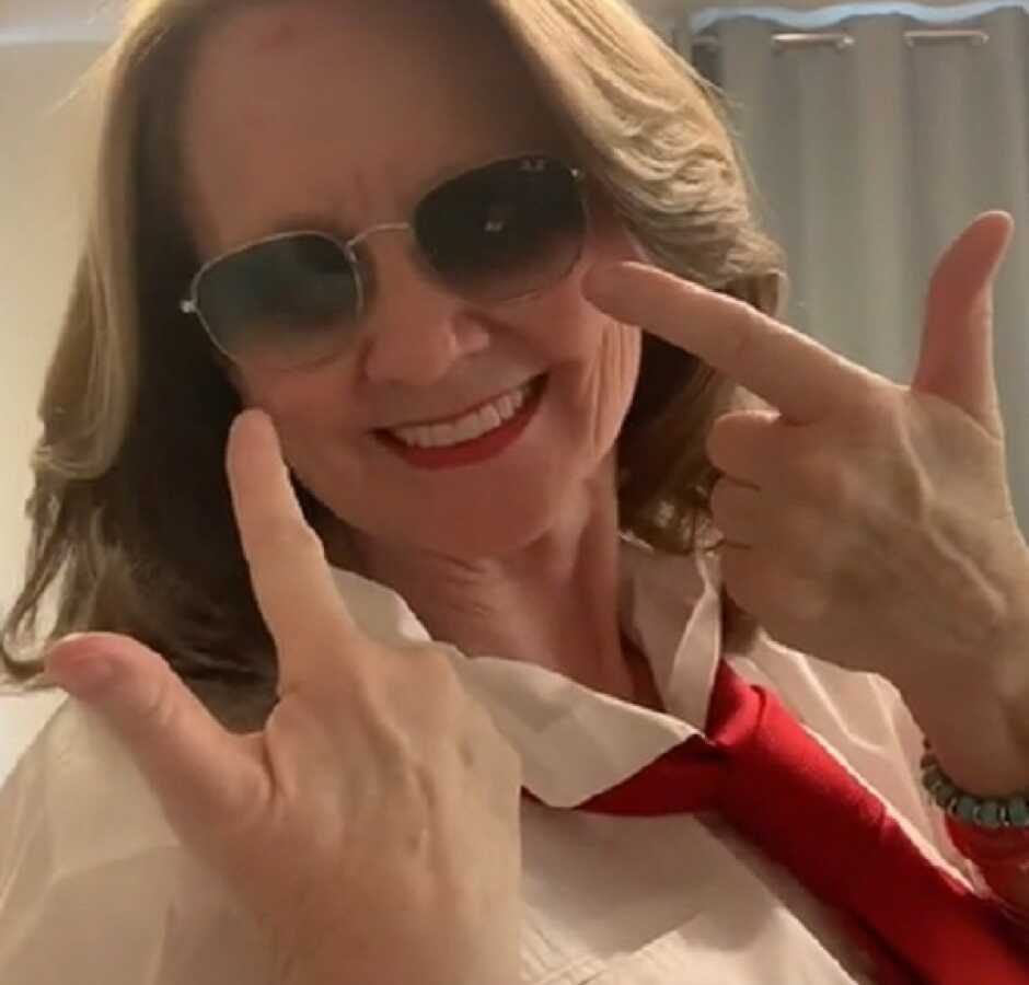 woman showing off her freshly done hair in sunglasses and red lipstick