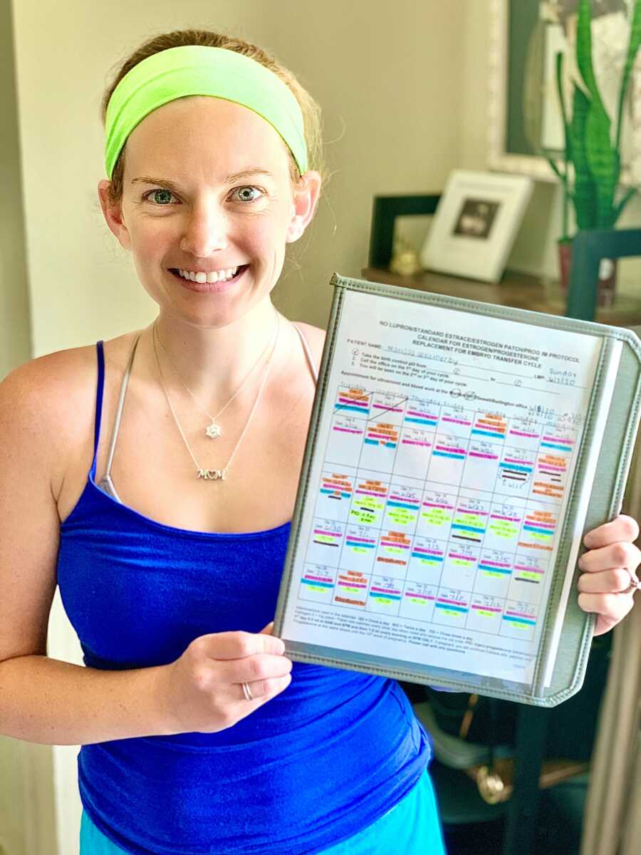 mom holding up a schedule on a clip board in a blue shirt