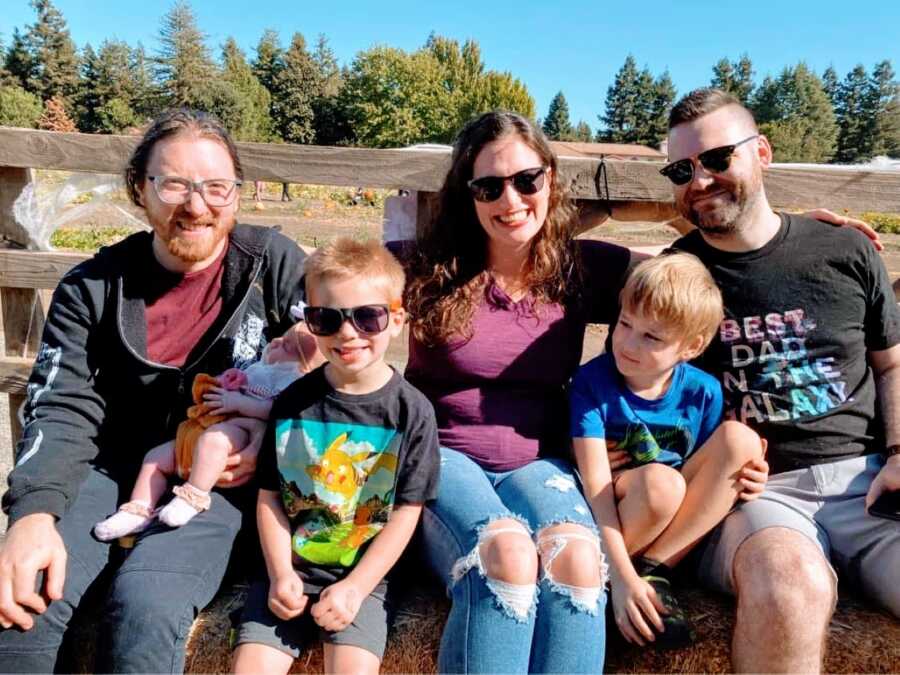 Couple and co-parents take a photo with their blended family while on a hayride together