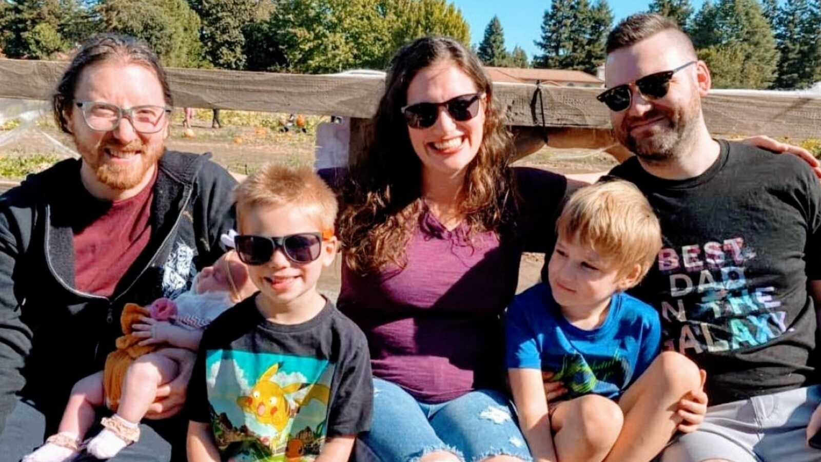 Co-parents take a photo with their children while all on a hayride together