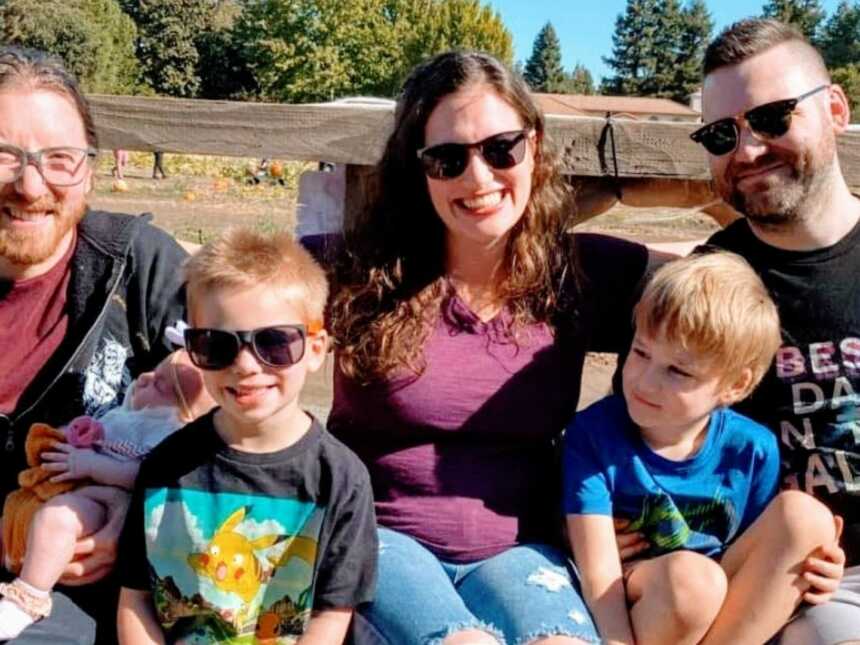 Co-parents take a photo with their children while all on a hayride together