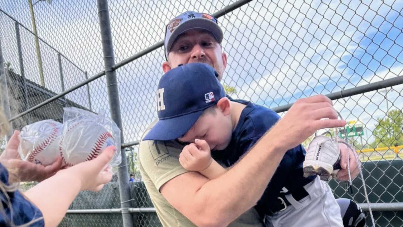 儿子一边哭一边拥抱他的父亲，父亲在他的t型球比赛中给了他一个惊喜