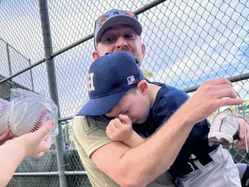 儿子在拥抱他的父亲时哭泣，他在他的T-ball比赛中对他感到惊讶