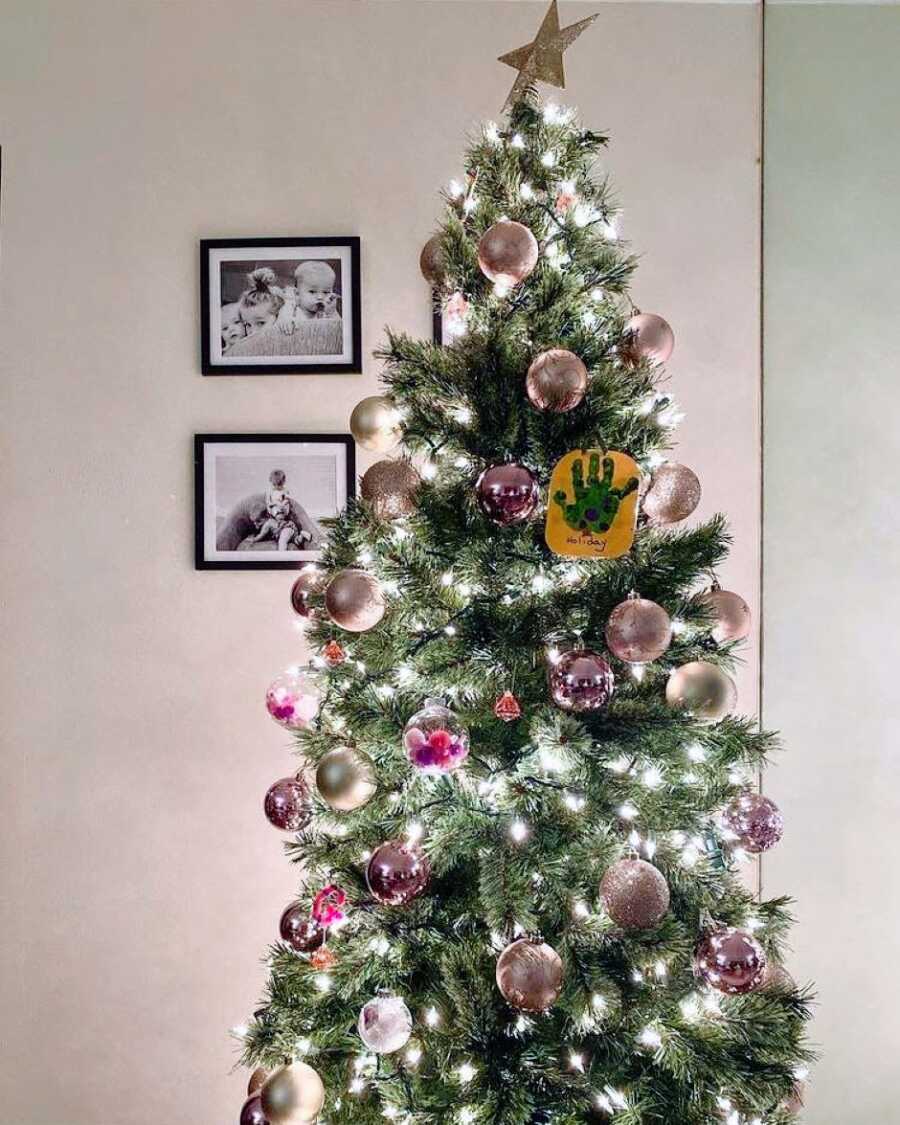 Mom snaps a photo of her Christmas tree covered in pink ornaments for her daughter who loves pink everything