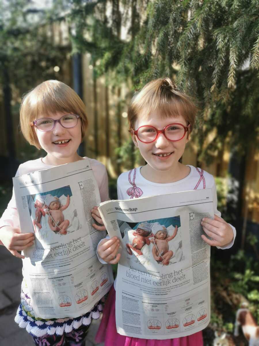 girls holding newspaper