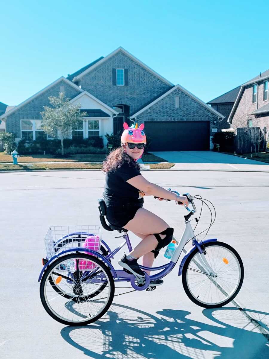 Young girl with epilepsy rides on her new purple bike for her 15th birthday 