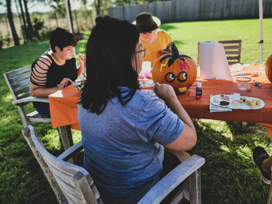 New friends paint pumpkins at a Halloween-themed Disney birthday party for a girl with epilepsy