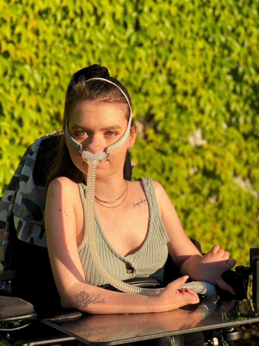 woman in wheelchair taking photo at golden hour