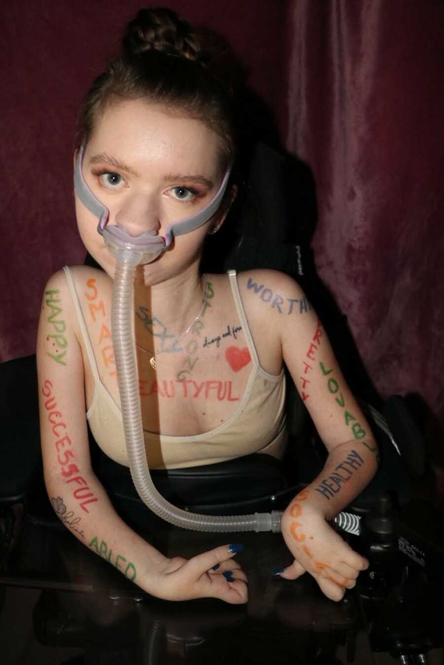 woman in wheelchair wrote all the words that she feels about herself on her body