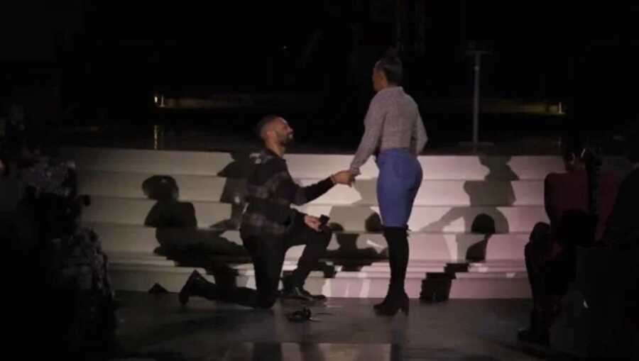 man proposing to his girlfriend at an Adele concert