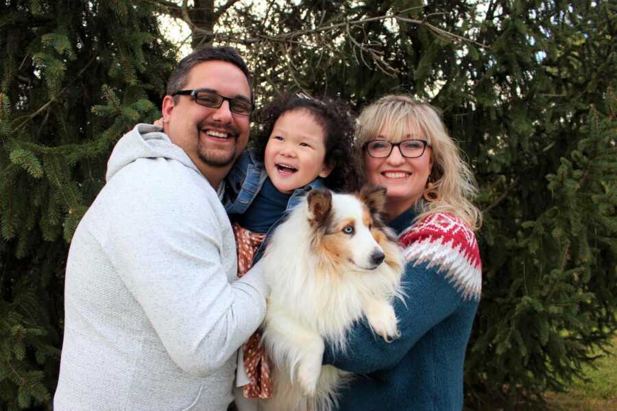 The Banion's smile for a family picture with their daughter and their dog. 