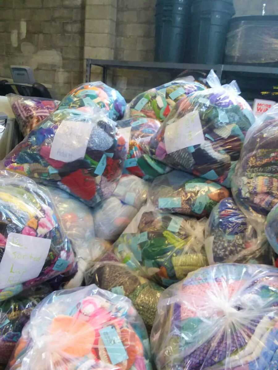 Bags full of donated crocheted winter clothing and blankets.