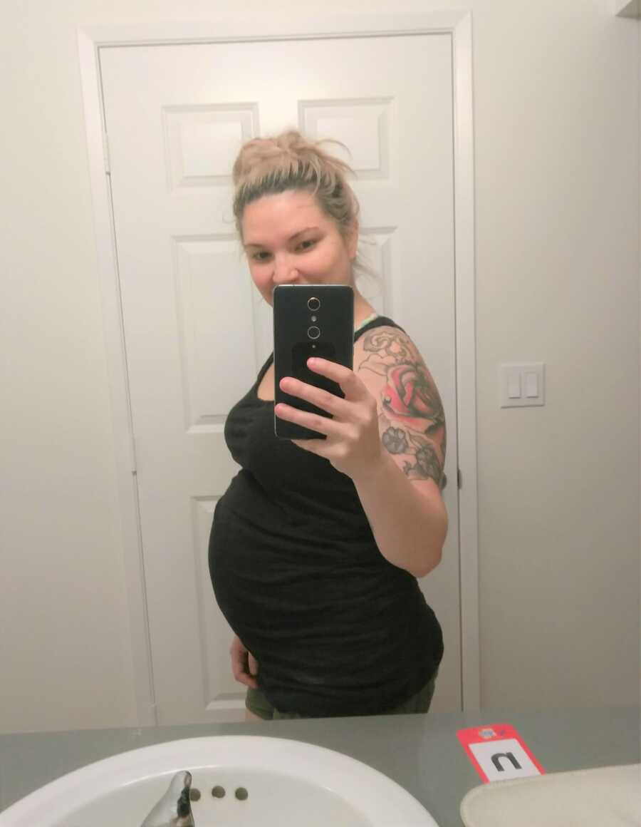 Breinne takes a picture of her baby bump at 8 months pregnant. 
